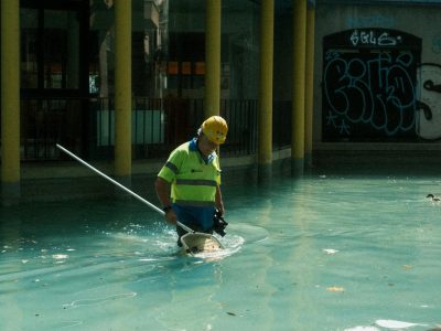 pexels-photo-21327976-21327976 A pool maintenance worker wearing safety gear cleans an outdoor pool in Barcelona, Spain.