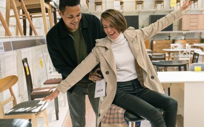 A cheerful couple enjoying their time shopping for furniture indoors.